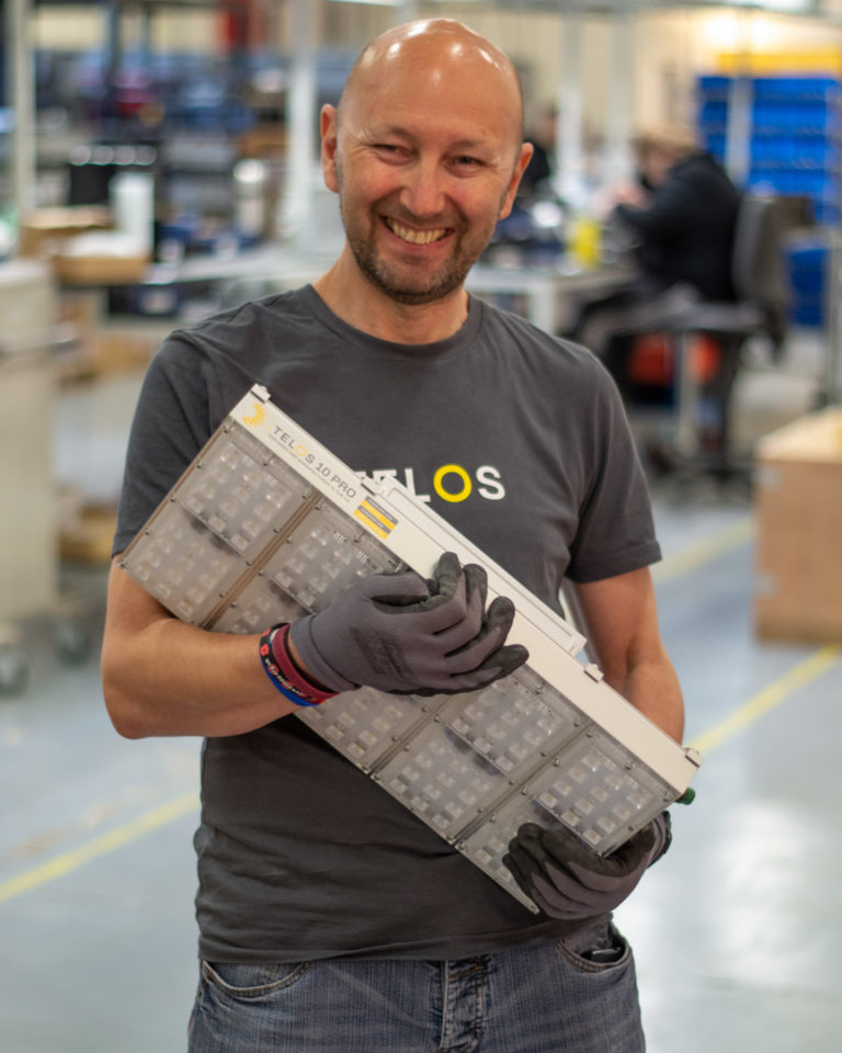 Telos employee holding Telos 10 Pro original in factory